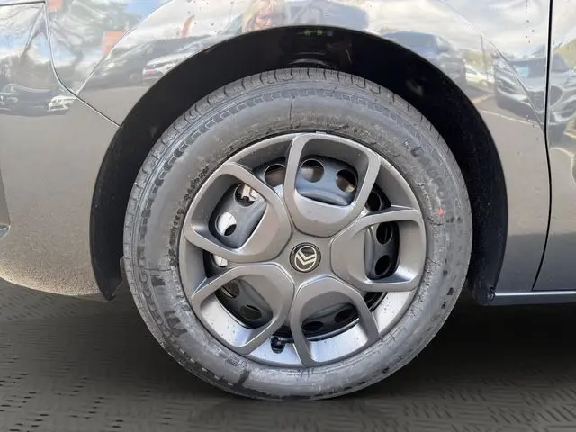 Gros plan sur la roue avant gauche d'un Citroën Jumpy gris titane avec jante tôle noire et enjoliveur design.