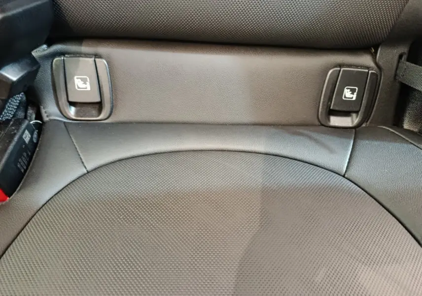 Gros plan sur la banquette arrière en cuir noir du MINI Countryman 2023, avec commandes rabattage sièges visibles.