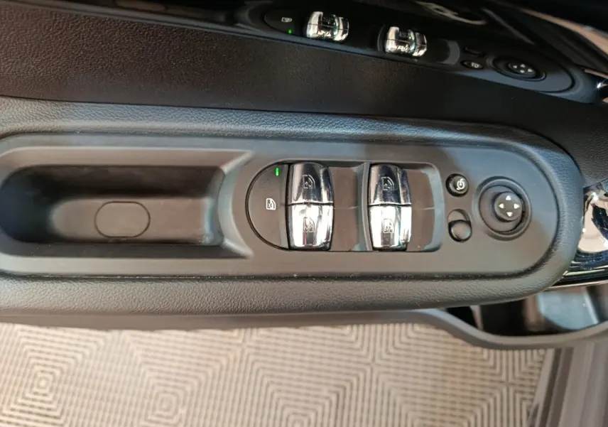 Gros plan sur les commandes des vitres et rétroviseurs côté conducteur du MINI Countryman gris foncé 2023.