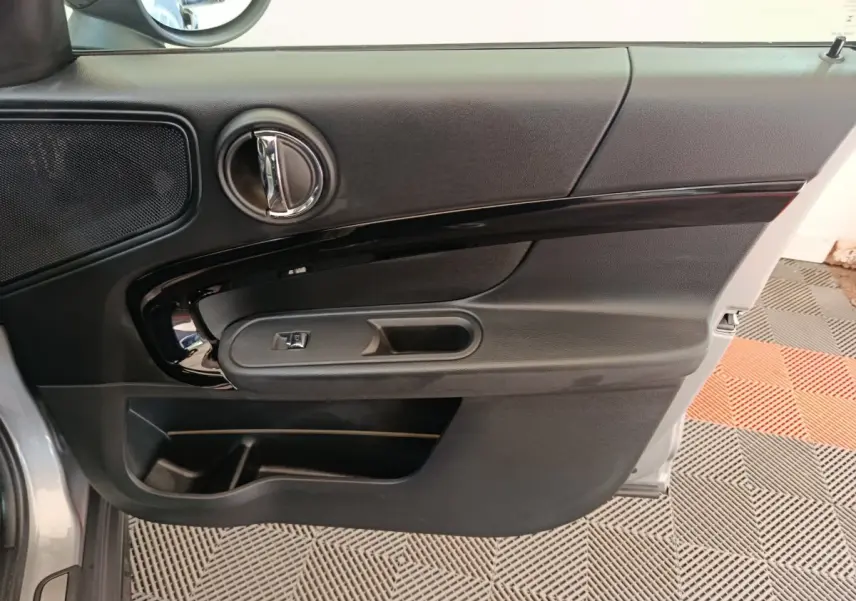 Vue rapprochée de la porte avant gauche gris foncé du MINI Countryman Cooper Edition Premium Plus 2023 avec poignée et commande de vitre.