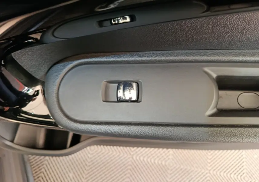 Gros plan sur la commande de verrouillage centralisé sur la portière côté conducteur d’un MINI Countryman gris foncé.