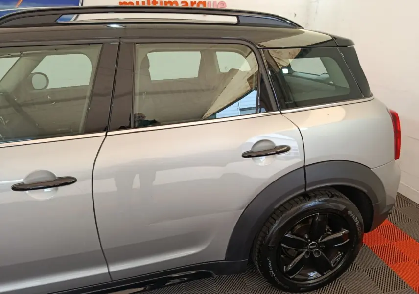 Vue latérale droite d'un MINI Countryman gris foncé avec toit noir et jantes noires brillantes.