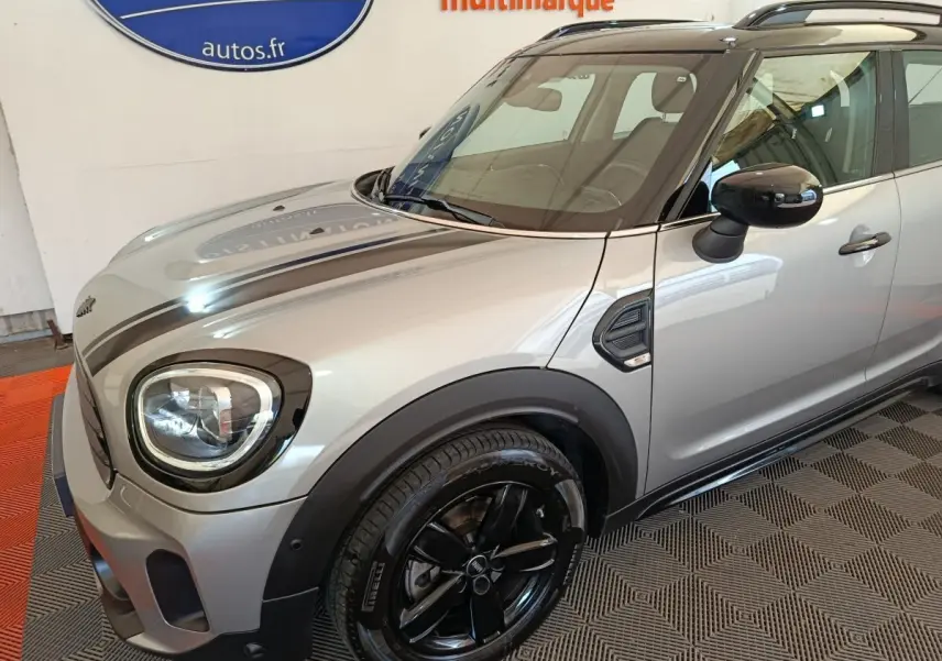 Vue 3/4 avant droit d'une MINI Countryman Cooper Premium Plus gris foncé avec jantes noires et toit noir.