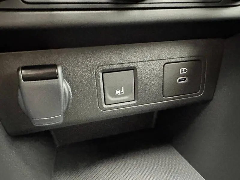 Gros plan sur les commandes et prises USB noires du tableau de bord du Dacia Jogger gris Schiste métallisé.