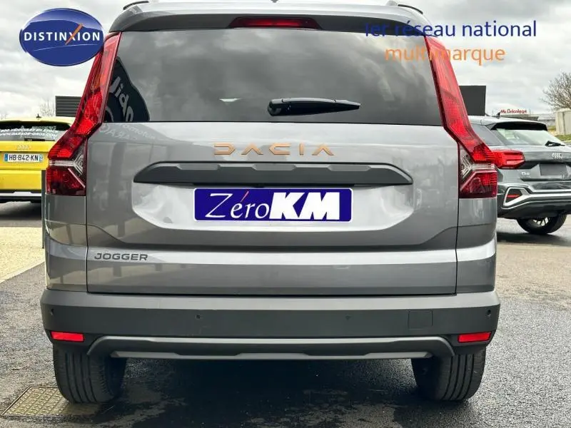 Vue arrière d'un Dacia Jogger gris schiste métallisé avec feux arrière verticaux et logo DACIA cuivré.
