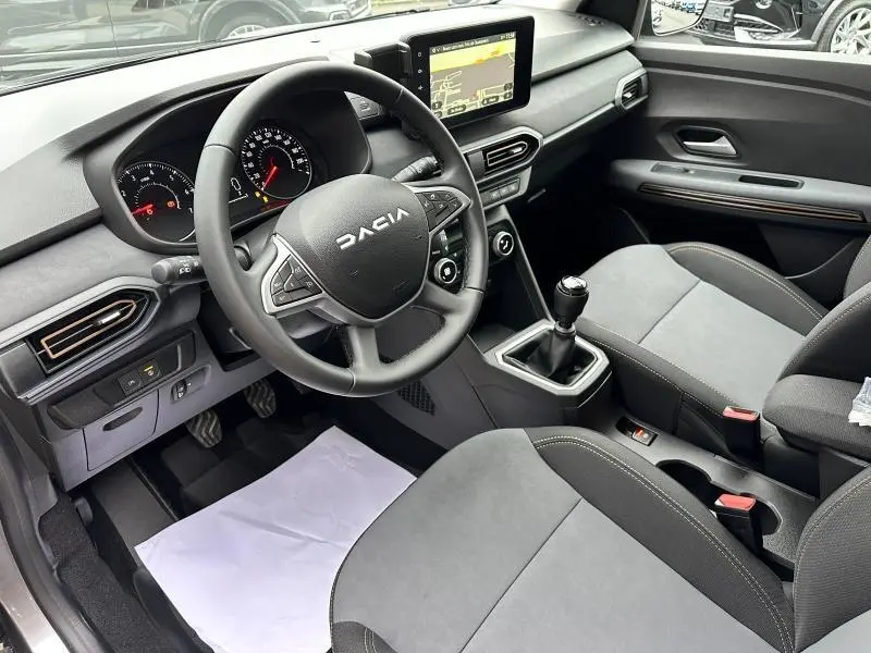 Intérieur avant du Dacia Jogger 2024, vue côté conducteur, volant multifonctions, écran tactile et sièges gris.