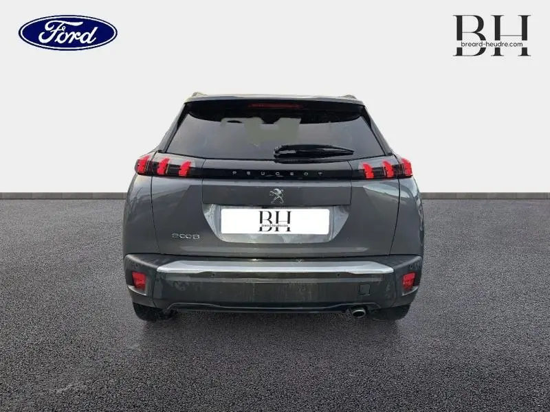 Vue arrière d'un Peugeot 2008 gris Artense avec feux LED distinctifs et becquet arrière visible.