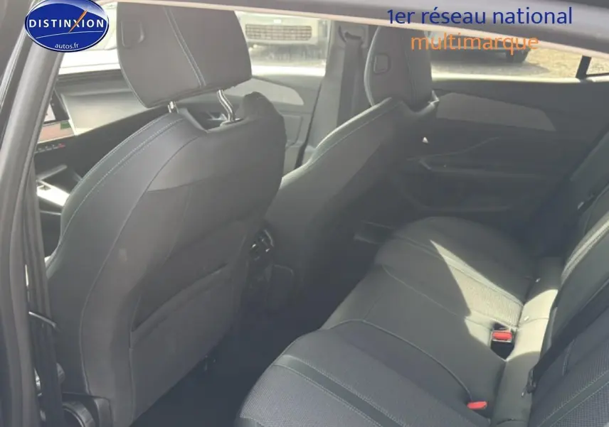 Vue intérieure arrière côté droit de la Peugeot 408 Hybrid 136 allure e-dcs6 noire, sièges en tissu et cuir avec surpiqûres contrastées.
