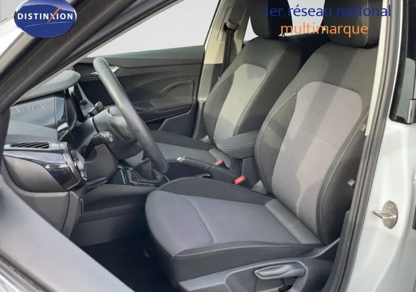 Vue intérieure côté conducteur de la Skoda Fabia blanc glacier 2025, montrant les sièges tissu gris et le tableau de bord moderne.