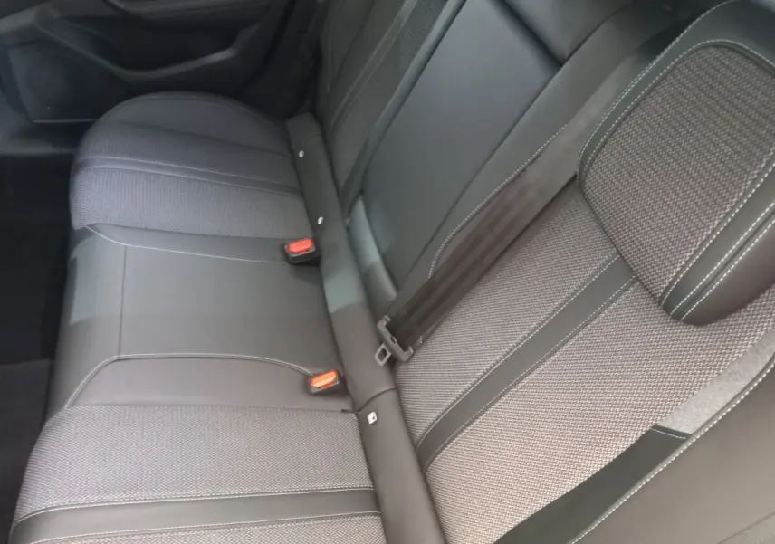 Vue rapprochée de la banquette arrière grise et noire de la Peugeot 308 PureTech 130, avec ceintures et appuie-tête visibles.