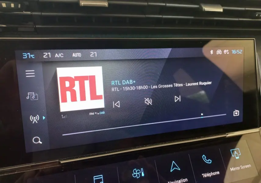 Écran tactile central de la Peugeot 308 bleu, affichant la radio RTL avec commandes multimédia visibles.