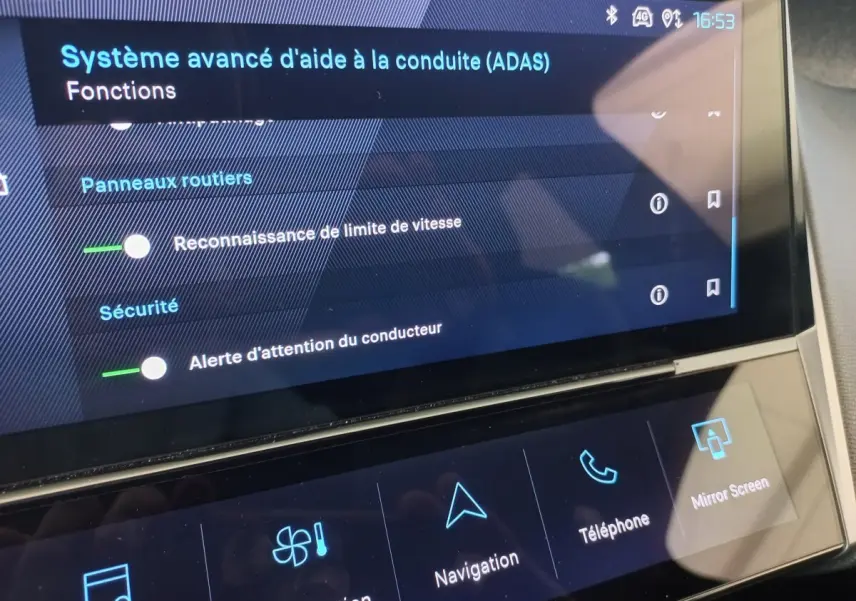 Écran tactile central de la Peugeot 308 bleu, affichant les options avancées d’aide à la conduite et navigation.