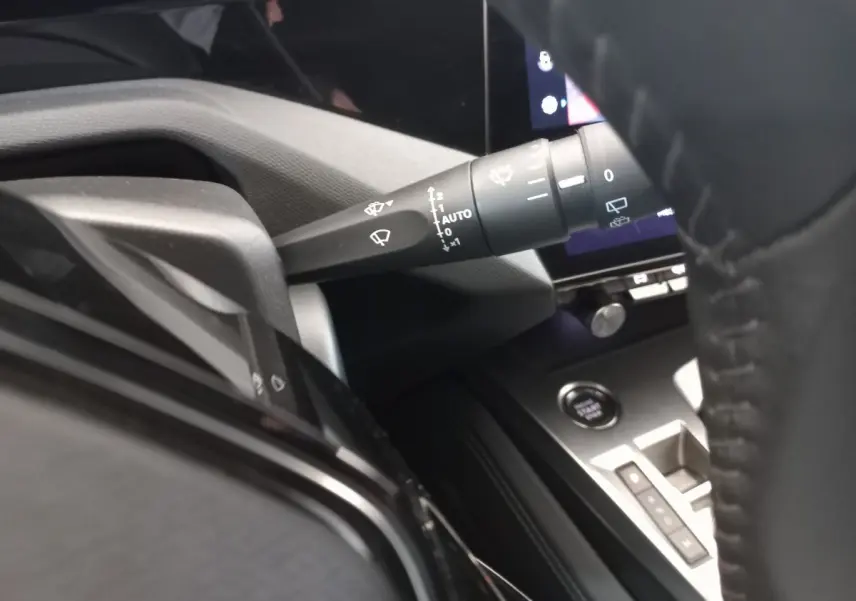 Détail intérieur du Peugeot 308 PureTech 130, montrant la commande d’essuie-glace et le bouton de démarrage, côté conducteur.