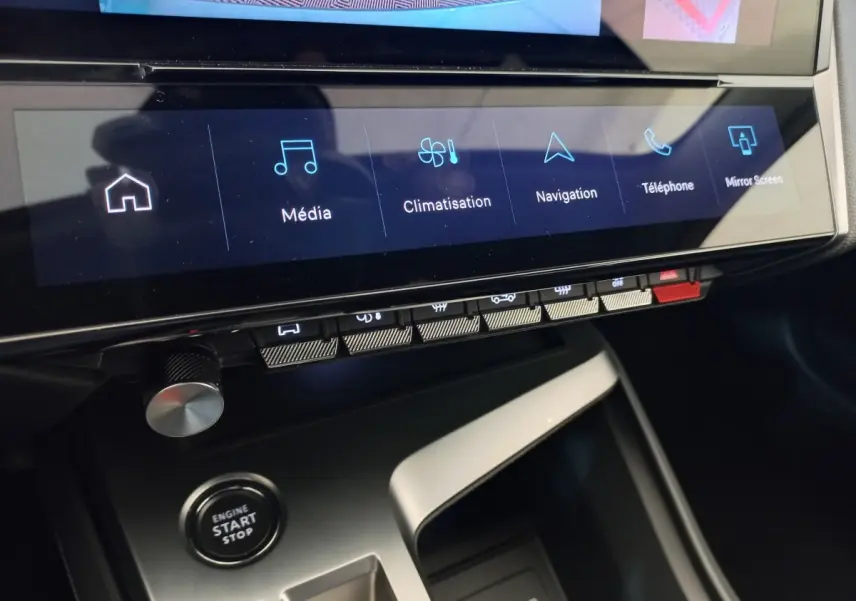 Vue rapprochée de la console centrale de la Peugeot 308 2022, écran tactile avec options média, navigation et bouton start/stop.