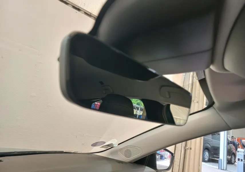 Vue intérieure du rétroviseur central d'une Peugeot 308 bleu, avec partie du tableau de bord et pare-brise visible.