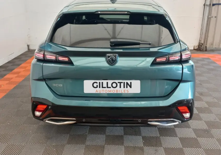 Vue arrière d'une Peugeot 308 bleu métallisé 2022 avec feux LED et double sortie d'échappement chromée.
