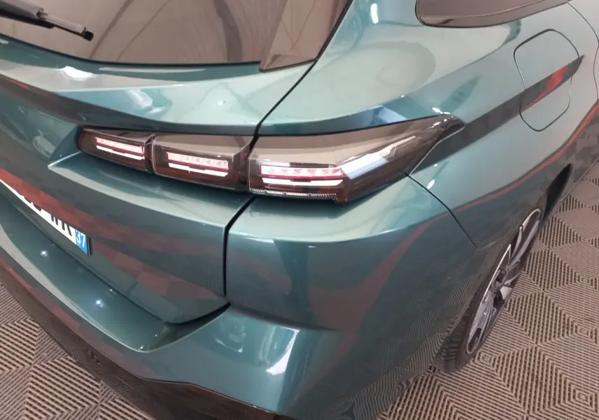 Vue 3/4 arrière droite d'une Peugeot 308 bleu métallisé avec feux arrière LED distinctifs et jante alliage.