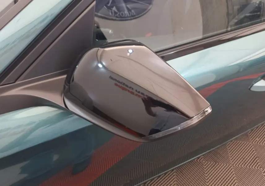 Rétroviseur droit noir brillant de la Peugeot 308 bleu, vue rapprochée sur la portière côté droit.