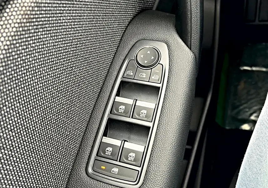 Gros plan sur les commandes des vitres électriques et rétroviseurs sur la porte côté conducteur du Renault Symbioz 2026.