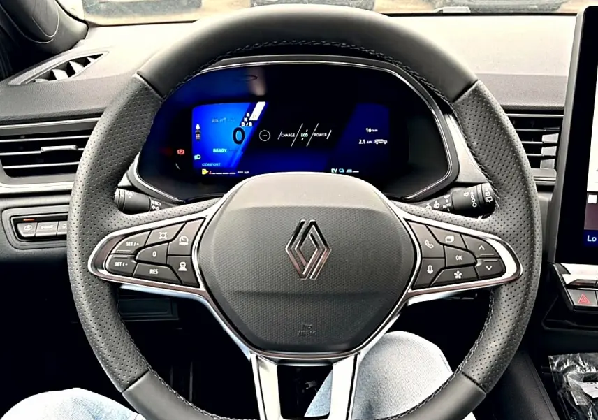 Vue frontale du volant perforé de la Renault Symbioz 2026 avec tableau de bord numérique bleu et commandes intégrées.