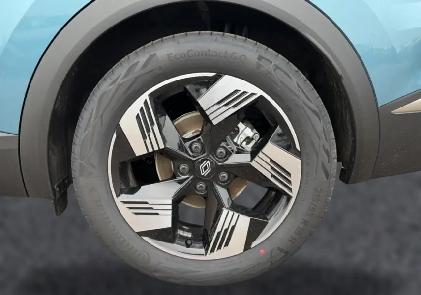 Gros plan sur la roue avant droite du Renault Symbioz bleu mercure, avec jante alliage noire et argent au design géométrique.