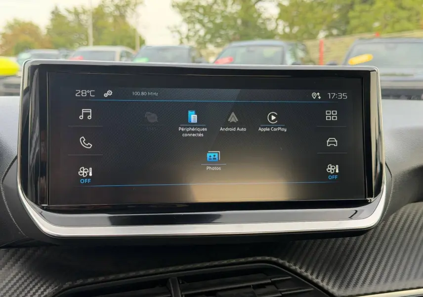 Écran tactile central du tableau de bord du Peugeot 208 1.2 Hybrid blanc, affichant Android Auto et Apple CarPlay.
