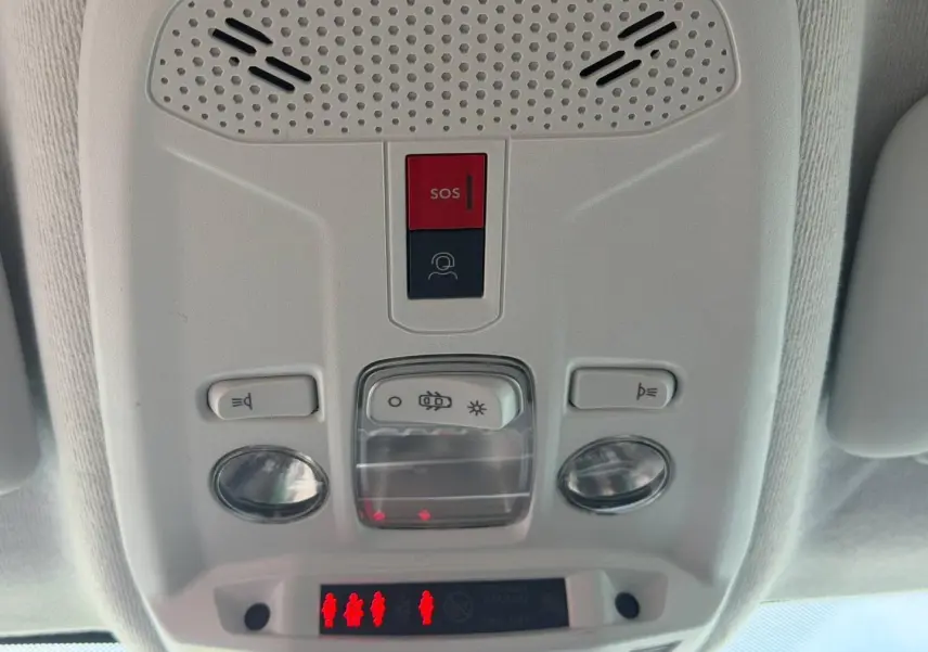 Vue en gros plan du plafonnier blanc avec boutons SOS et éclairage intérieur de la Peugeot 208 hybride 2025.