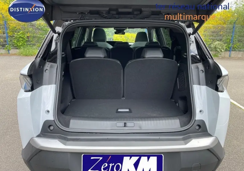 Vue arrière ouverte du Peugeot 5008 hybride blanc Okenite avec toit noir, montrant le coffre et les sièges arrière.