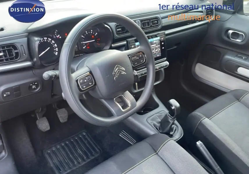 Vue intérieure côté conducteur de la Citroën C3 sable métal 2022, avec volant multifonction et boîte manuelle.