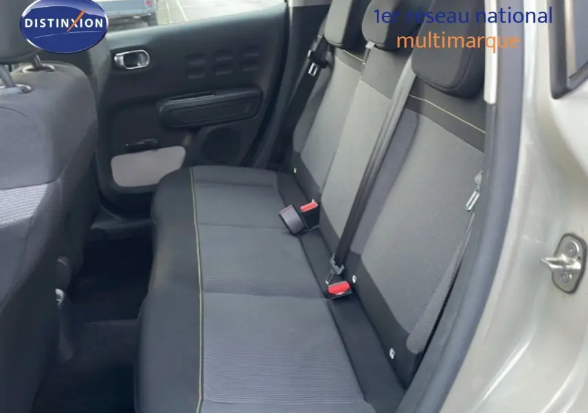 Vue intérieure côté droit montrant la banquette arrière en tissu gris avec surpiqûres jaunes d'une Citroën C3 sable métal 2022.