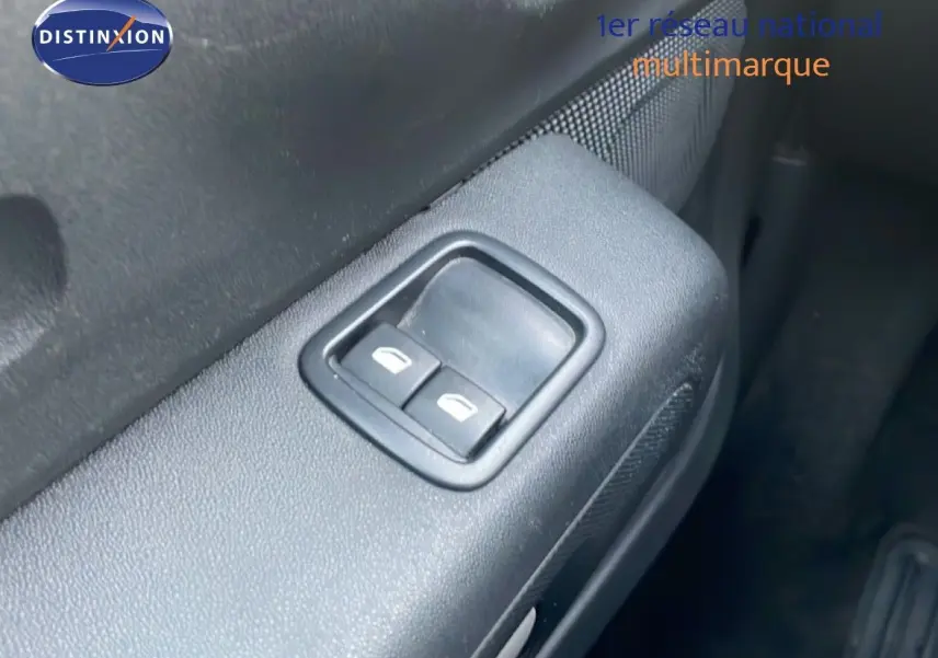 Gros plan sur les commandes des vitres électriques côté conducteur d’une Citroën C3 2022 finition sable métal.