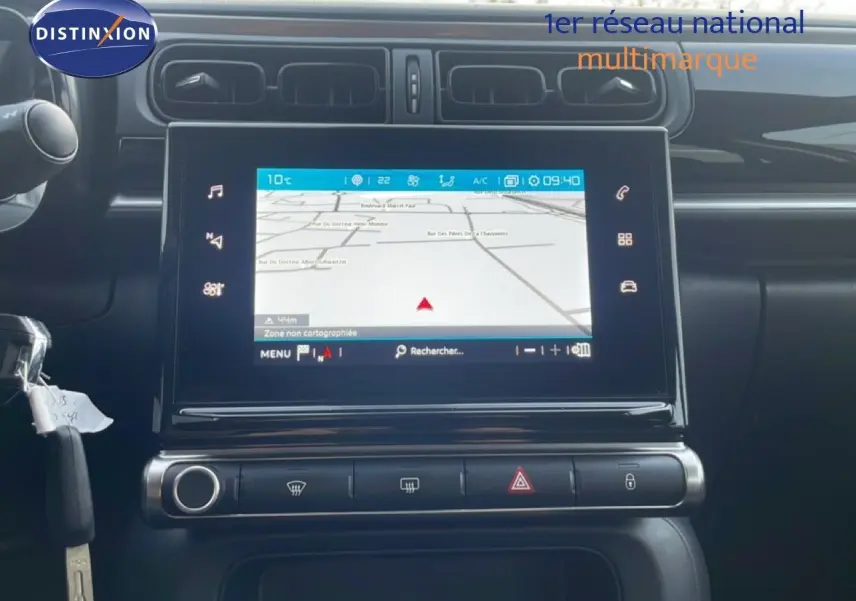 Vue rapprochée de la console centrale de la Citroën C3 sable métal 2022, avec écran tactile GPS et commandes climatisation.