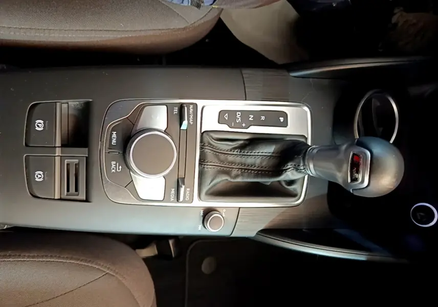 Vue plongeante sur la console centrale noire de l'Audi A3 30 TDI 2019 avec levier de vitesse S tronic et molette de commande multimédia.