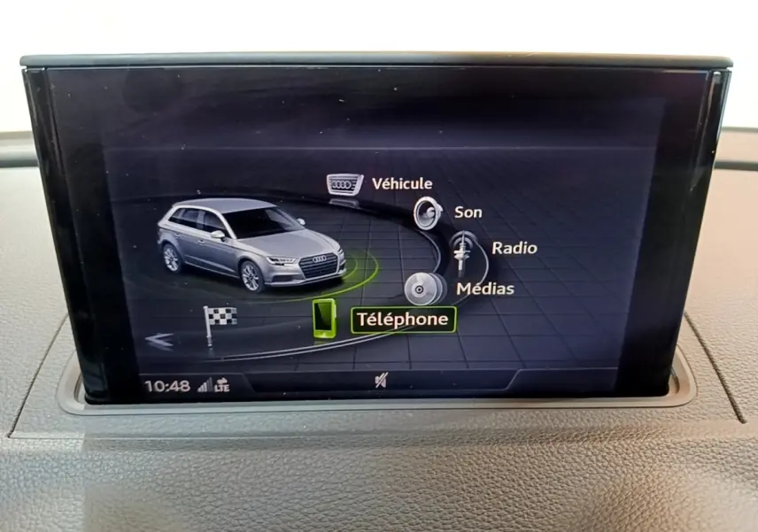 Écran central affichant la voiture Audi A3 gris foncé en vue 3/4 avant avec menu multimédia et téléphone sélectionné.