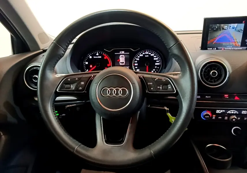 Vue frontale du volant cuir multifonctions noir de l'Audi A3 30 TDI 116 S tronic Business Line avec tableau de bord et écran multimédia.