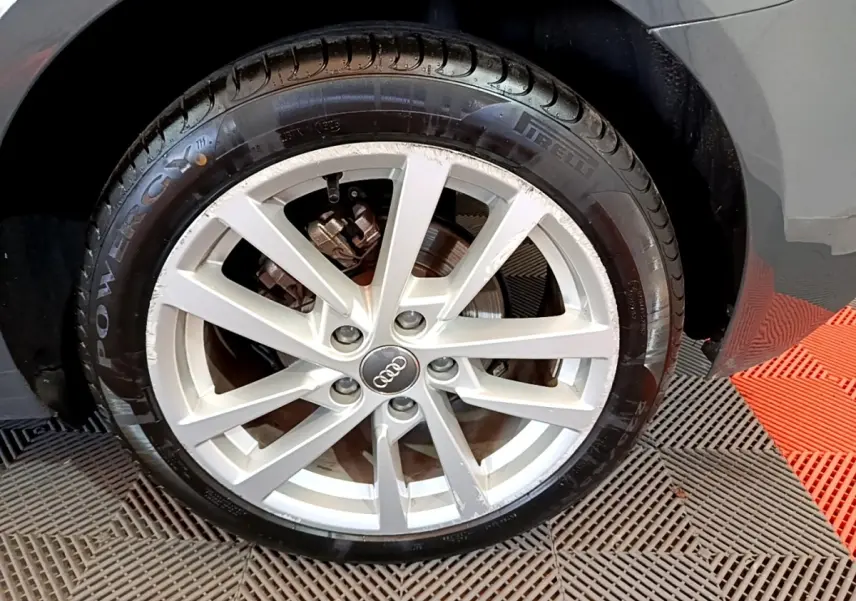 Gros plan sur la roue avant droite gris foncé d’une Audi A3 30 TDI 116 S tronic Business Line avec jante argentée.