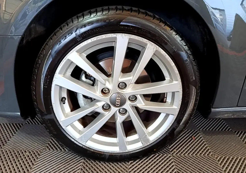 Gros plan sur la roue avant droite gris foncé d'une Audi A3 30 TDI 116 S tronic Business Line avec jante alliage argentée.