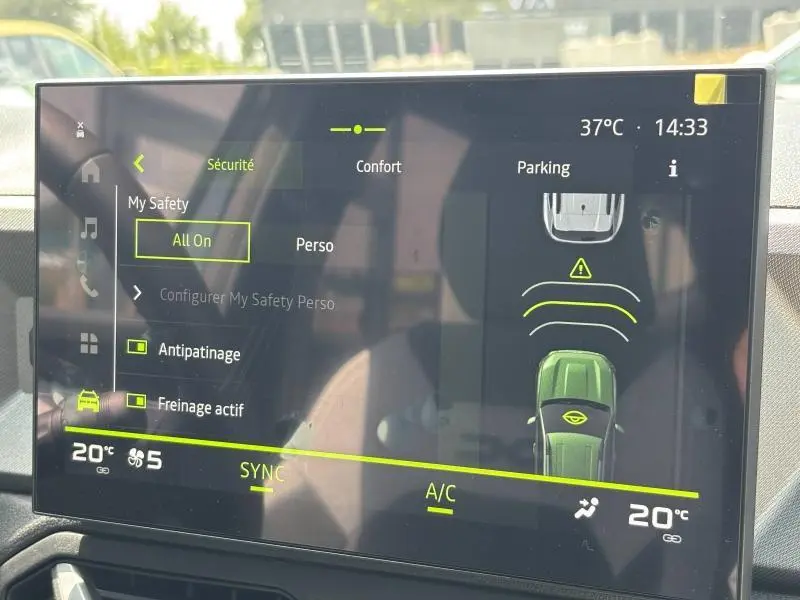 Écran tactile intérieur du Dacia Bigster blanc montrant l'assistance au stationnement et réglages de sécurité.