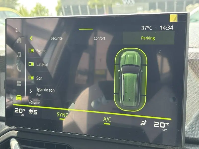 Écran tactile intérieur du Dacia Bigster blanc montrant l'aide au stationnement et les réglages climatiques.