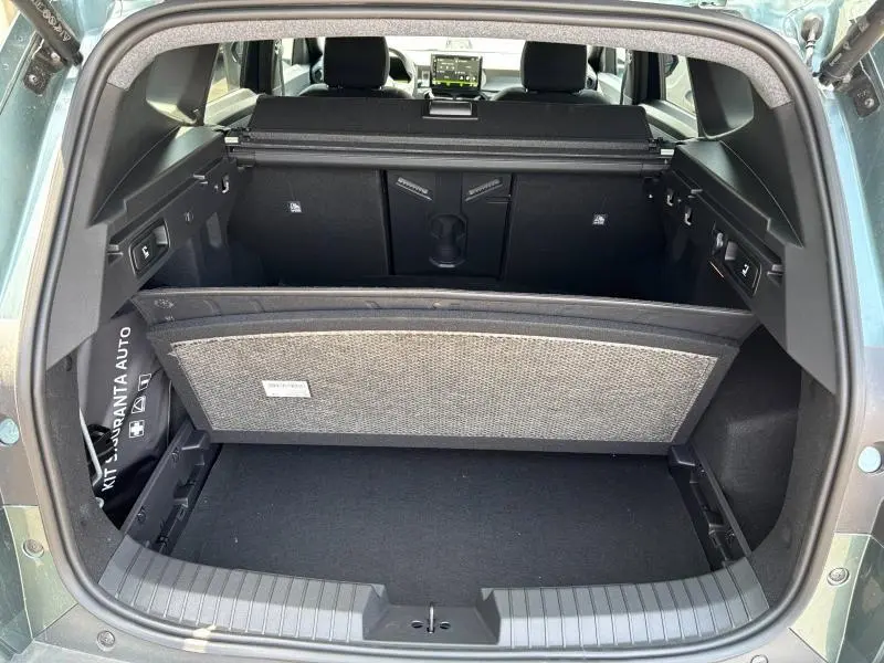 Coffre ouvert vu de l'arrière du Dacia Bigster blanc, avec tablette cache-bagages et banquette arrière visible.