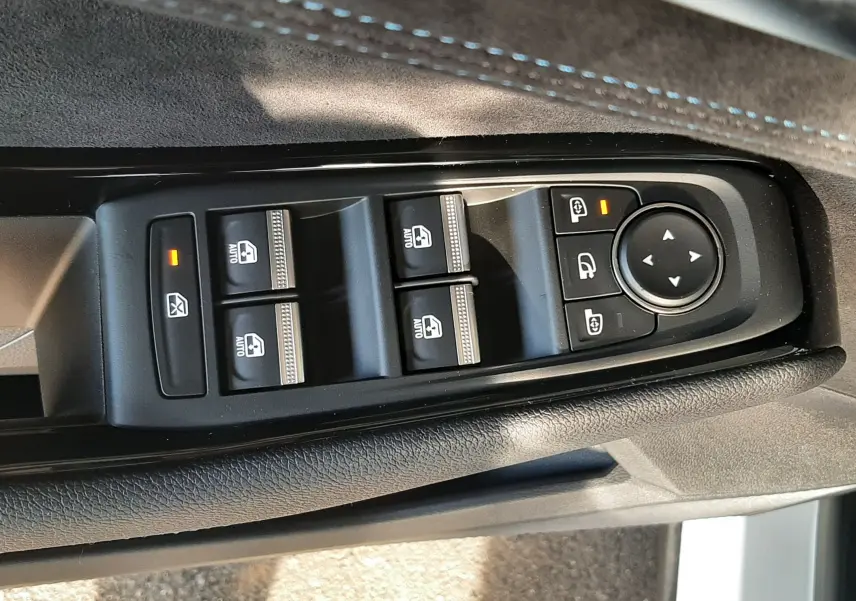 Vue rapprochée des commandes de lève-vitres et rétroviseurs sur la porte côté conducteur du Renault Austral blanc nacré.