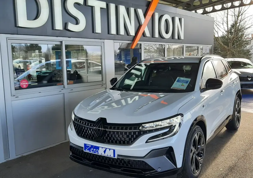 Renault Austral E-Tech hybride blanc nacré avec toit noir, vue 3/4 avant droit, calandre noire et jantes noires distinctives.