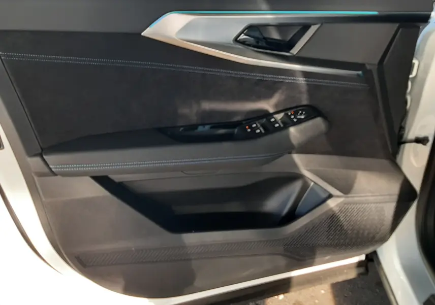 Vue intérieure de la porte avant gauche du Renault Austral 2025 blanc nacré, avec commandes électriques et finition noire.