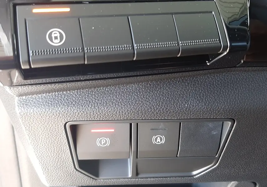 Détail des commandes intérieures noires du tableau de bord du Renault Austral E-Tech blanc nacré, avec voyants rouges allumés.