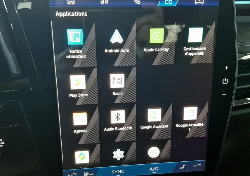 Écran tactile central de la Renault Austral 2025 affichant les applications connectées, dans un intérieur noir.