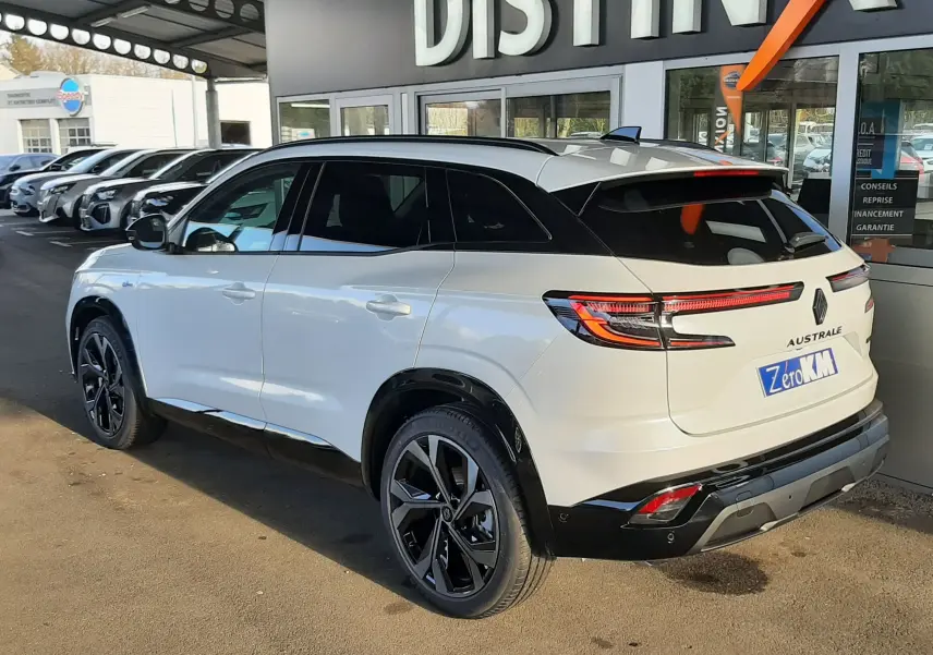 Vue 3/4 arrière droite du Renault Austral blanc nacré avec toit noir, feux arrière LED et jantes noires distinctives.