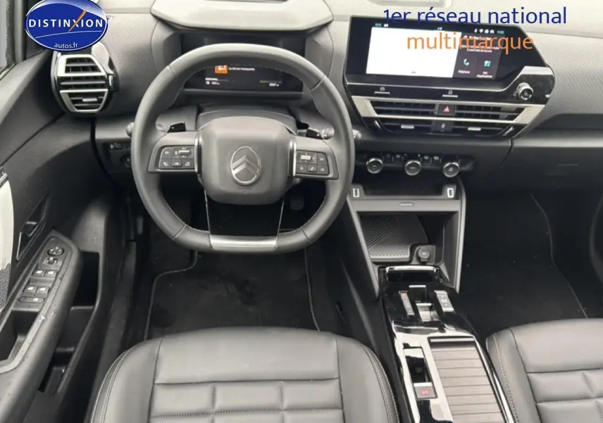 Vue intérieure avant de la Citroën C4 noire 2025, volant cuir, écran tactile et console centrale brillante.