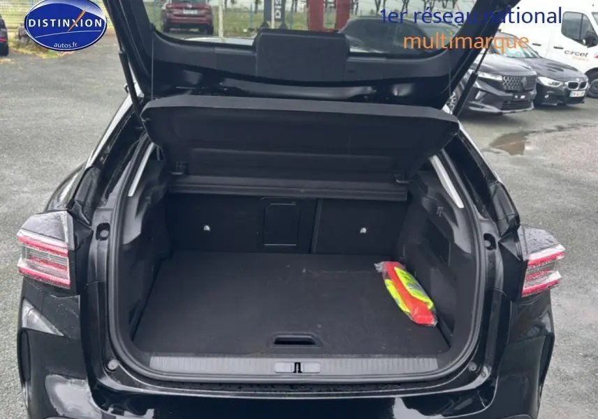 Coffre ouvert vu de l'arrière d'une Citroën C4 noire 2025 avec feux arrière LED et espace de chargement vide.