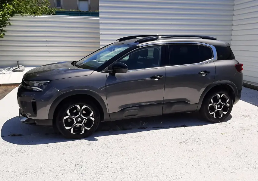 Vue latérale droite du Citroën C5 Aircross hybride gris platinium avec toit noir et jantes distinctives en alliage.