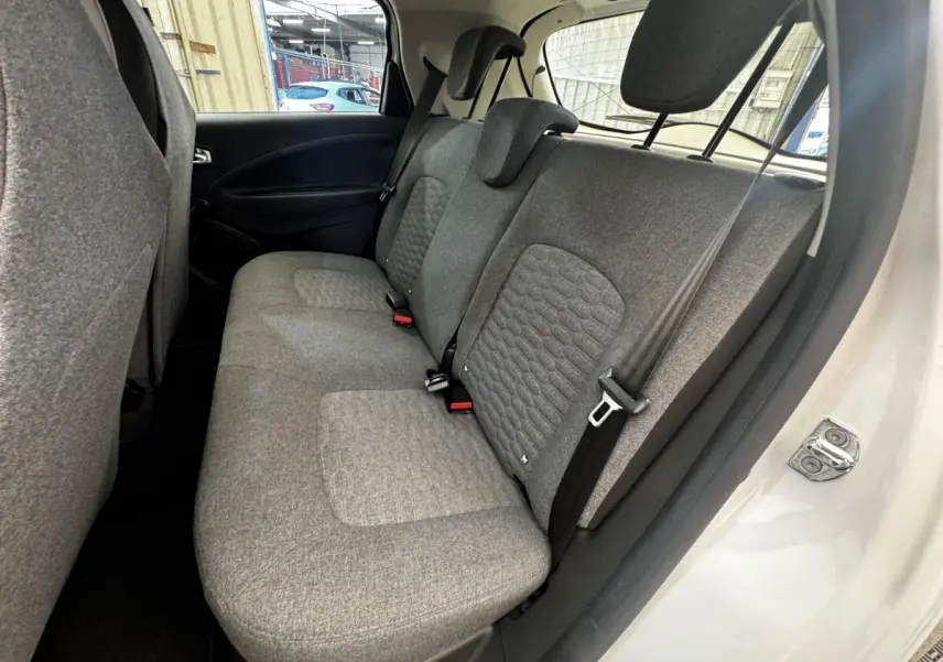 Vue côté droit sur la banquette arrière grise de la Renault ZOE blanche Iconic R135 2022, avec ceinture de sécurité visible.